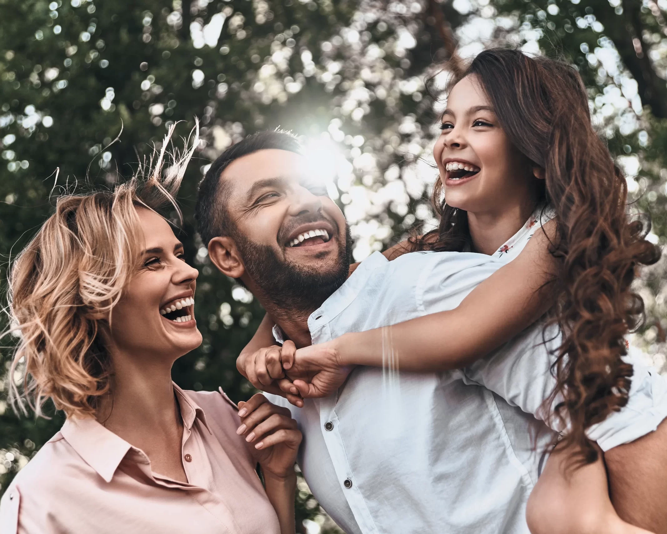 Famiglia felice che ride e gioca all'aperto in un ambiente naturale
