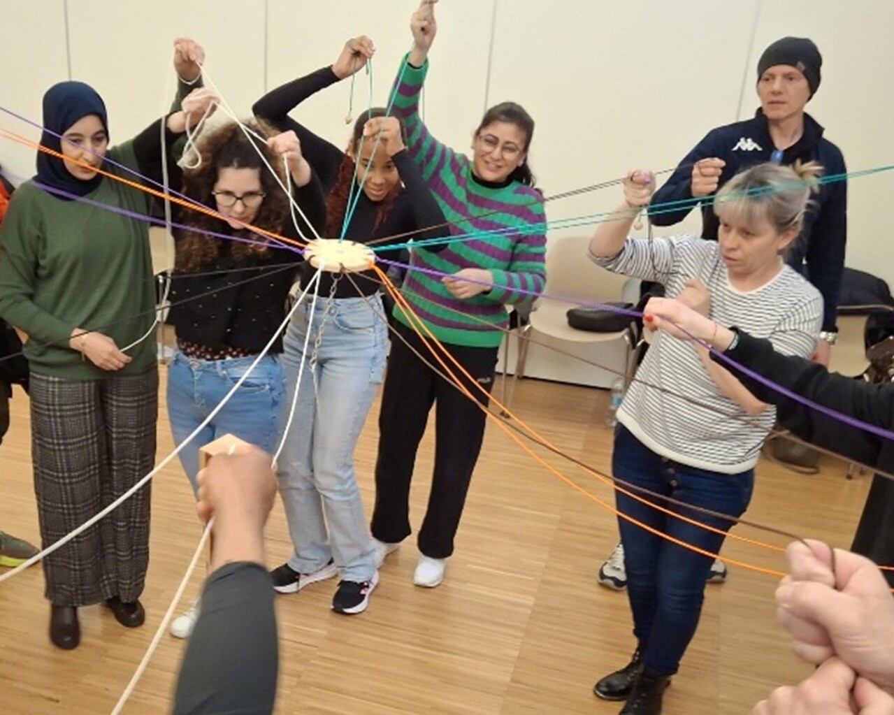 Group of people participating in a team building activity with coloured threads