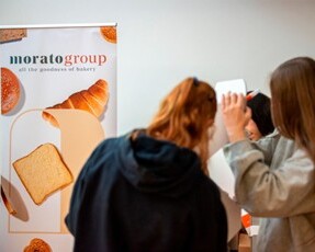 Stand promozionale del Morato Group con prodotti da forno e visitatori che interagiscono
