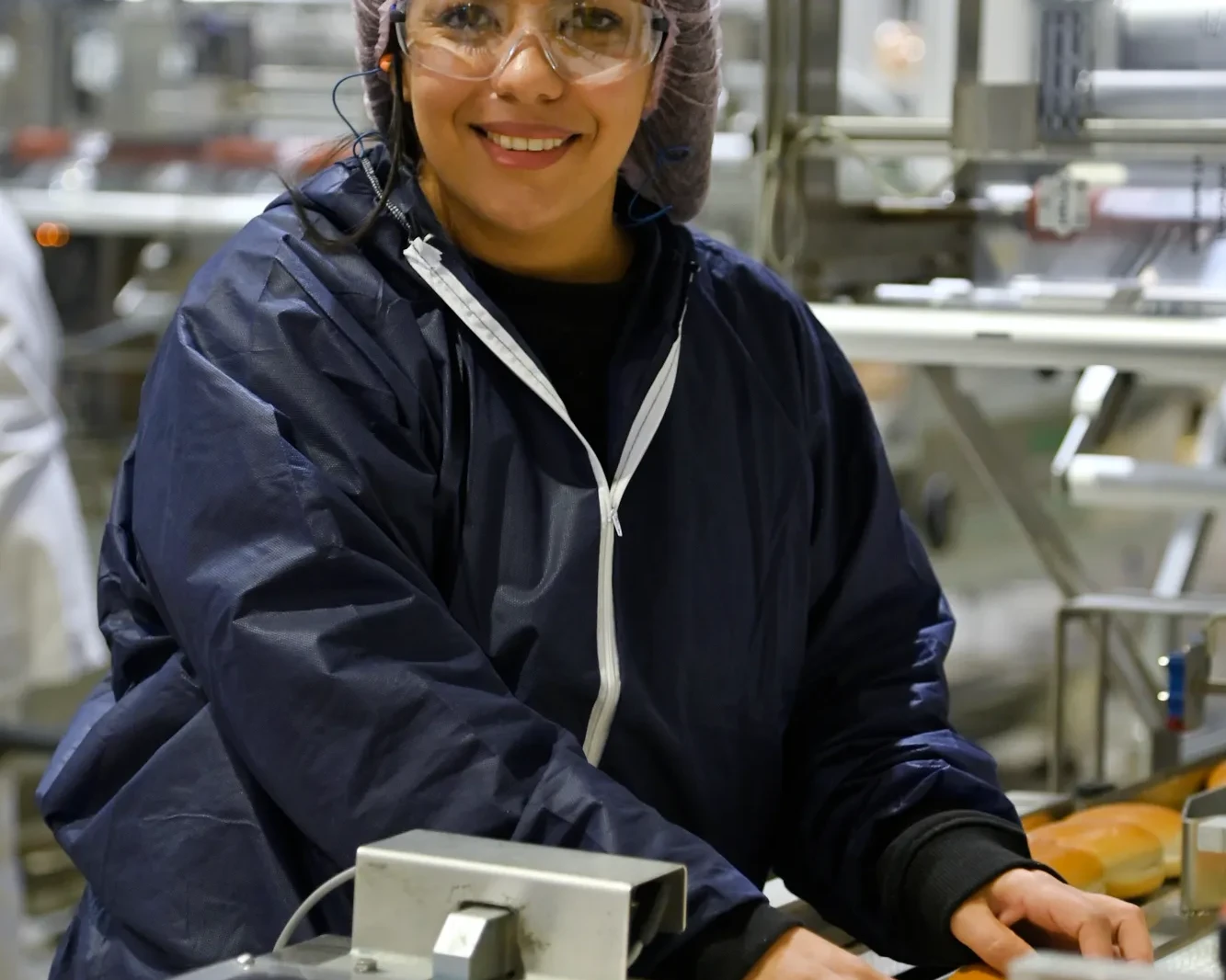 Woman in a food industry checking sandwiches on a production line