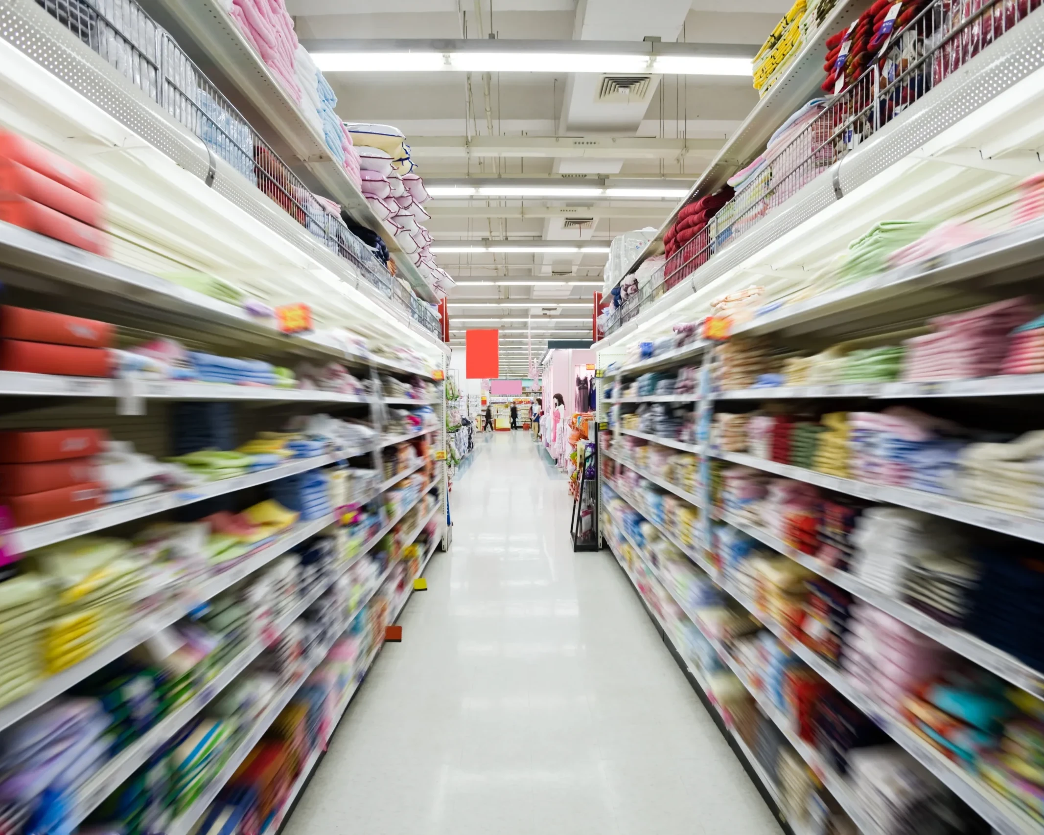 Interno di un supermercato con corsie piene di prodotti vari su scaffali